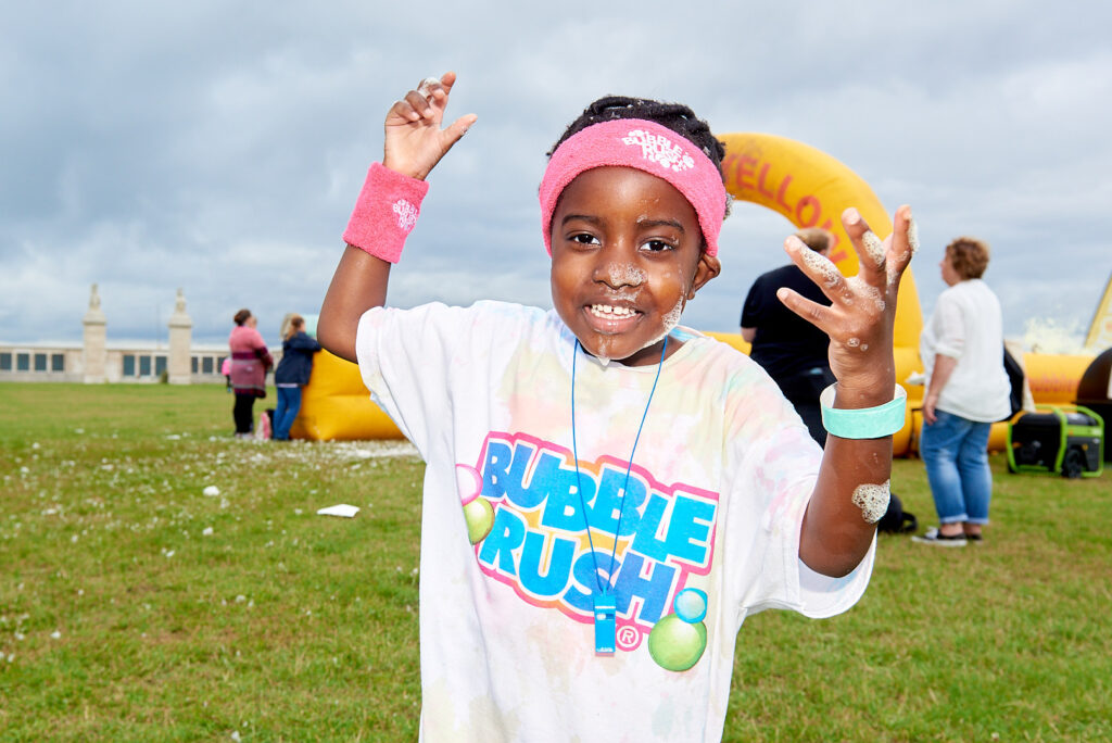 Young Boy Taking Part in Bubble Rush Smiling